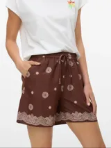 Short de tiro medio color marrón con estampado de mandalas y flores en tono beige claro. Presenta un borde inferior con un patrón tipo paisley en el mismo color y ajuste de cordón en la cintura.