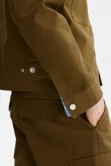 Pantalón cargo de algodón en color verde militar con corte relajado, bolsillos al bies en los laterales, bolsillos de parche con solapa en las piernas y cierre frontal con botón a presión.