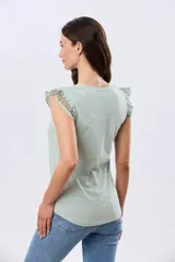 Remera color verde menta sin mangas con detalles de broderie calado en los hombros y canesú superior.