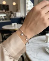 Pulsera doble de plata 925, compuesta por cadenas finas decoradas con pequeñas esferas y charms colgantes en forma de estrellas y corazones.