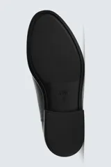 Bota estilo Chelsea de cuero negro con diseño liso, paneles elásticos laterales y tirador trasero. Presenta horma redonda y suela con tacón bajo.
