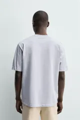 Camiseta regular fit de color beige, confeccionada en tejido de algodón compacto, con cuello redondo y manga corta.