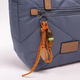 Bandolera tipo shopper azul con diseño acolchado, doble asa de mano en tono tostado y correa ajustable desmontable. Cuenta con cierre superior, bolsillo frontal con cierre y detalle de llavero colgante con cordones naranjas y cuentas.