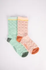 Pack de dos pares de medias de caña media con diseño de puntos en relieve. Un par es color verde agua con puntera y talón verde oscuro y ribete amarillo. El otro par es color rosa pálido con puntera y talón naranja y ribete amarillo.