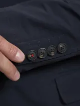 Blazer color marrón claro, de corte clásico, con solapas de muesca, cierre de dos botones, bolsillo en el pecho y bolsillos laterales con solapa.