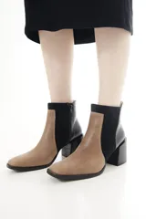 Botas cortas de cuero vacuno en combinación de colores tostado y negro, con diseño bicolor y paneles laterales de gamuza, punta cuadrada y taco bloque ancho.