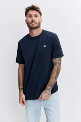 Remera de algodón color azul marino, de corte clásico y cuello redondo, con un pequeño logo bordado en el pecho.
