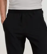 Pantalón deportivo masculino de corte recto, confeccionado en microfibra técnica. Presenta cintura elástica con ajuste y bolsillos laterales con cierre de cremallera.