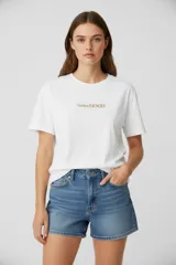 Remera de algodón de manga corta, con cuello redondo y diseño holgado. Presenta un estampado frontal con la frase 'Golden MOOD' en letras doradas.