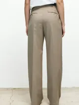 Pantalón de vestir de corte sastrero, tiro alto y pierna recta. Presenta pinzas frontales, bolsillos laterales y cierre con botón y cremallera.