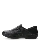 Zapato casual tipo mocasín de cuero negro, con costuras blancas visibles en contraste y un pequeño lazo decorativo en el empeine. Posee suela de goma negra y un diseño cómodo.