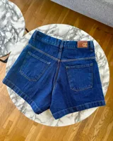 Short de jean azul oscuro, de tiro medio/alto, con corte semi baggy y relajado. Confeccionado en denim 100% algodón.