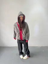 Campera reversible con cierre frontal, confeccionada en algodón de alto gramaje con estampa plastisol y bordado con aplique en un lado, y tela polar de pelo largo en el reverso. Presenta diseño oversize, capucha integrada y puños acanalados.
