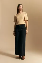 Remera de rib color beige, con cuello redondo y mangas cortas amplias con leve frunce en los hombros. Confeccionada en tejido elastizado de textura acanalada.