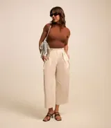 Pantalón carrot color beige confeccionado en tricolina con efecto empapelado, cierre tradicional y pliegues.