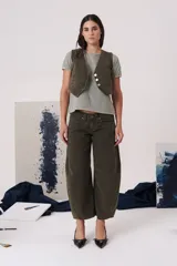 Chaleco de gabardina color blanco, con escote en V, cierre frontal con botones y bolsillos delanteros simulados.