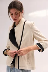 Chaqueta de lino lavado color blanco, con cuello mao, cierre metálico diagonal y detalles en contratono.