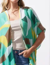 Kimono tejido de poliéster con estampado geométrico en tonos verde, amarillo, blanco y marrón. Presenta mangas amplias tipo japonesa y terminación de ruedo con borlas.