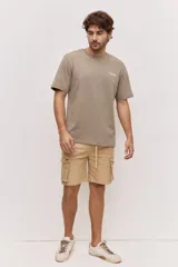Remera blanca de algodón, de corte holgado y mangas cortas, con pequeño estampado azul en el pecho.