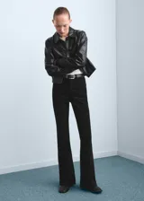 Jeans negros de corte flare, tiro medio y diseño clásico con bolsillos.