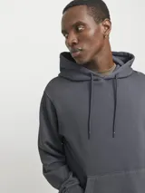 Buzo con capucha gris, de algodón y corte holgado. Tiene capucha forrada, bolsillo tipo canguro y mangas largas.