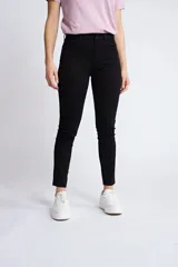 Pantalón de gabardina corte skinny, color beige, con diseño de cinco bolsillos, cierre de cremallera y botón frontal.