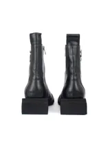 Bota de cuero color negro con punta cuadrada, suela de cuero y taco cuadrado. Presenta cierre lateral de metal plateado y herraje metálico decorativo en el lateral.