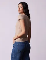 Remera color beige de tejido acanalado, con escote a la base y manga corta.