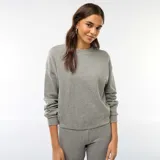 Buzo de punto de textura suave y gruesa, color gris, con cuello redondo y mangas largas con puños elásticos.