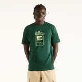 Remera New Balance de hombre, color verde oscuro, de manga corta y corte amplio. Presenta un estampado frontal de estilo pixel art inspirado en el efecto 2000 que representa un televisor retro y un champión.