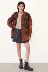 Parka de jean oversize con acabado lavado, cuello clásico, bolsillos frontales con tapa y cierre frontal. Presenta un diseño de silueta amplia y relajada con puños regulables.