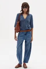 Jean de corte barrel con tiro medio y ajuste relajado. Confeccionado en denim de algodón con un toque de spandex, presenta diseño de cinco bolsillos, cierre frontal con botón y costuras reforzadas en las rodillas.