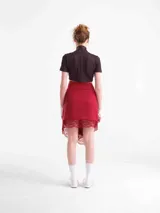 Falda larga cruzada de tencel color rojo, ajustable con tiras laterales y detalles de encaje en el borde inferior y la cintura.