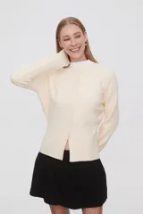 Saco negro de punto, con cuello redondo a la base, manga larga y cierre frontal con botones.