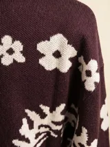 Cardigan de punto color cacao con estampado floral en color crema, cuello abrigado y cierre frontal de botones.