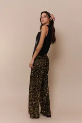 Pantalón palazzo negro con lentejuelas doradas.