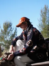 Gorra de cuero color camel con visera curva y ajuste trasero con hebilla metálica.