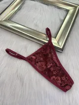 Pack de tres microtangas de encaje con diseño floral, cuentan con tiras laterales regulables y bordes con terminación en cinta elástica. El set incluye una prenda negra, una blanca con estampado floral negro y una beige con estampado floral negro.