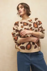 Sweater de punto color verde claro con estampado animal print en tonos marrones.
