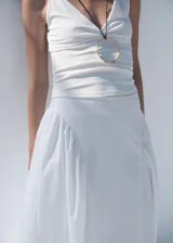 Falda midi de tiro alto con diseño evasé y fruncidos laterales. Confeccionada en algodón con forro interior de algodón y cierre de cremallera lateral.