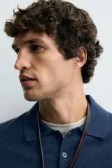 Polo de punto de corte regular fit, confeccionado en una mezcla de lana y cashmere. Presenta cuello solapa con cierre frontal de dos botones, manga larga y terminaciones en rib.