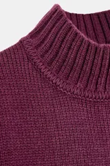 Jersey de punto liso con cuello subido, manga larga y acabados en rib en puños, cuello y ruedo.