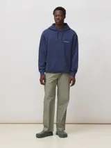 Hoodie azul marino de algodón orgánico con capucha, corte regular fit y un gran estampado en la espalda en forma de 'X' con bordes claros.
