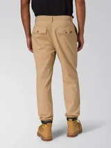 Pantalón chino beige de corte slim tapered, con bolsillos laterales y traseros, cierre de cremallera y botón, y tejido elástico.