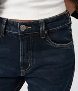 Pantalón de jeans premium azul oscuro de corte recto y cintura media, con bolsillos funcionales, trabillas para cinturón y costuras visibles a contratono. Confeccionado por Marfinno.