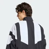 Campera deportiva Adidas Blocked de diseño bicolor en negro y blanco, con cuello alto, cierre frontal y bolsillos laterales. Presenta el logo del Trifolio bordado en el pecho.