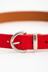 Cinto de gamuza color rojo con hebilla metálica plateada.