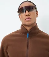 Buzo abierto de hombre confeccionado en tejido sherpa color marrón, con cuello alto, cierre frontal completo y bolsillos laterales. Presenta un diseño de calce regular con acabado interior polar para mayor abrigo.