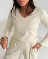 Remera de lanilla con textura acanalada, escote en V y mangas largas estilo oxford. Presenta un diseño ajustado al cuerpo.