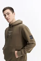 Canguro oversize de algodón, color negro, con capucha ajustable, bolsillo frontal tipo canguro y estampa sutil en el pecho.